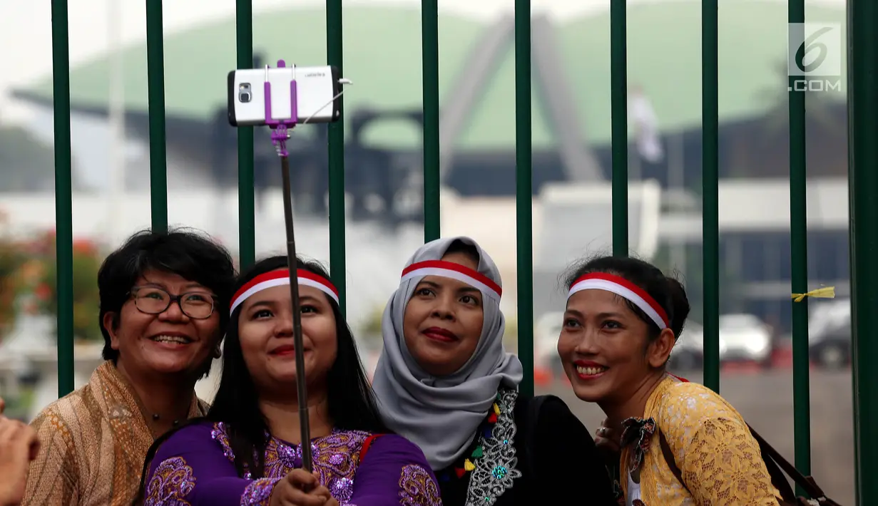 Massa dari Perempuan Peduli Indonesia berswafoto disela aksi mendukung pengesahan Perppu Ormas di depan Gedung DPR RI, Jakarta, Kamis (27/7). Kumpulan para ibu mendesak pemerintah untuk merealisasikan Perppu No 2 Tahun 2017. (Liputan6.com/Johan Tallo)