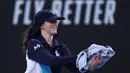 Seorang ball girl menangkap seekor serangga yang memasuki lapangan ketika laga Australia Open 2024 antara petenis Inggris, Emma Raducanu melawan petenis Amerika Serikat di Melbourne Park, Melbourne, Australia, Selasa (16/01/2024). (AFP/David Gray)