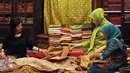 Peserta pameran merapikan deretan batik yang dipamerkan pada WARISAN 2016 di Jakarta, Kamis (25/8). Pameran ini berlangsung hingga Minggu (28/8) dan menampilkan beragam jenis batik baik tulis maupun cap original. (Liputan6.com/Helmi Fithriansyah)