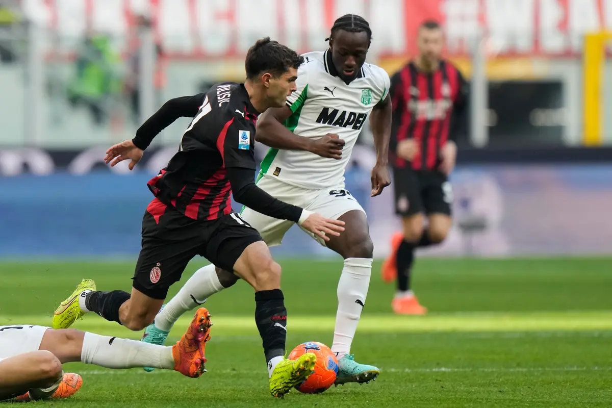 Christian Pulisic (kiri) dipepet Ismael Kone di laga AC Milan vs Sassuolo di pekan ke-15 Serie A 2025/2026 di San Siro, Minggu (14/12/2025). (AP Photo/Luca Bruno)
