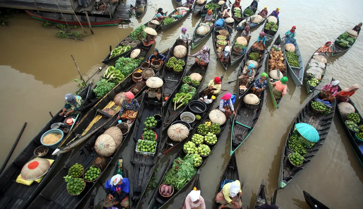 Pasar terapung Lok Baitan Indonesia ini buka sekitar pukul 5 pagi dan berlangsung selama sekitar tiga jam saja. Kebanyakan penjualnya adalah perempuan yang mengenakan baju tradisional. (AP Photo)