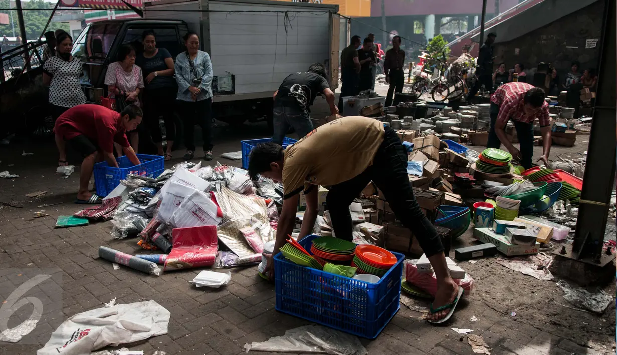 Warga menyelamatkan barang yang masih bisa dijual sisa dari kebakaran di Pasar Senen, Jakarta, Jumat (20/1). Badan Penanggulangan Bencana Daerah DKI Jakarta menyatakan jumlah kios Pasar Senen sebanyak 1.691 kios. (Liputan6.com/Gempur M Surya)