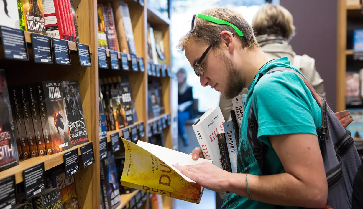 Aidan Devlon  melihat buku di toko Amazon Books di University Village, Seattle, Washington, Selasa (3/11). Setelah 20 tahun mejual buku secara online, akhirnya Amazon membuka toko buku fisik pertamanya. (AFP Photo/Jason Redmond)