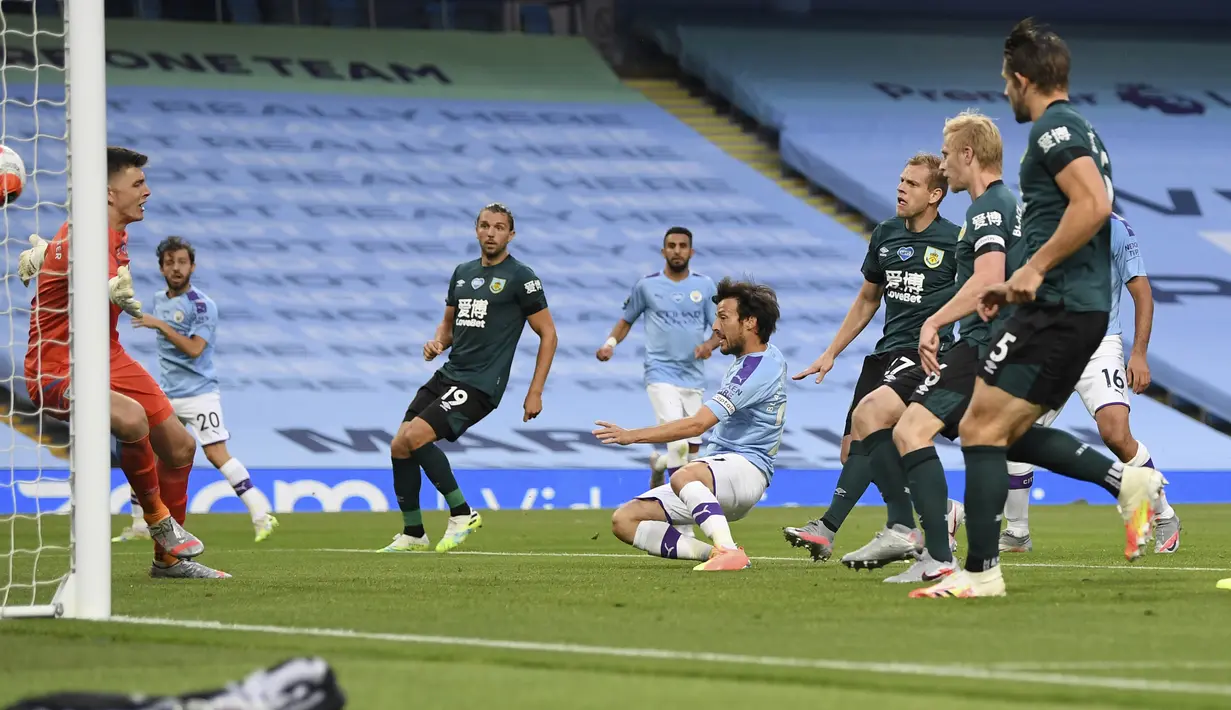 Pemain Manchester City, David Silva, mencetak gol ke gawang Burnley pada laga Premier League di Stadion Etihad, Senin (22/6/2020). Manchester City menang 5-0 atas Burnley. (AP/Shaun Botterill)