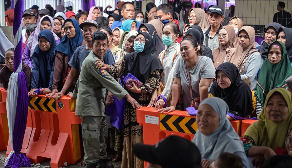 Untuk teknis pelaksanaannya masih sama seperti tahun-tahun sebelumnya, penerima cukup mengganti biaya administrasi kecil, namun bantuan diberikan sepenuhnya gratis. Tampak dalam foto, orang-orang mengantre untuk menerima barang-barang gratis seperti pakaian, bahan makanan pokok, dan perlengkapan rumah tangga yang disediakan oleh Asosiasi Organisasi Wanita (GOW) dan pemerintah daerah selama acara aksi sosial tahunan di bulan Ramadan, Surabaya pada Senin 2 Maret 2026. (JUNI KRISWANTO/AFP)