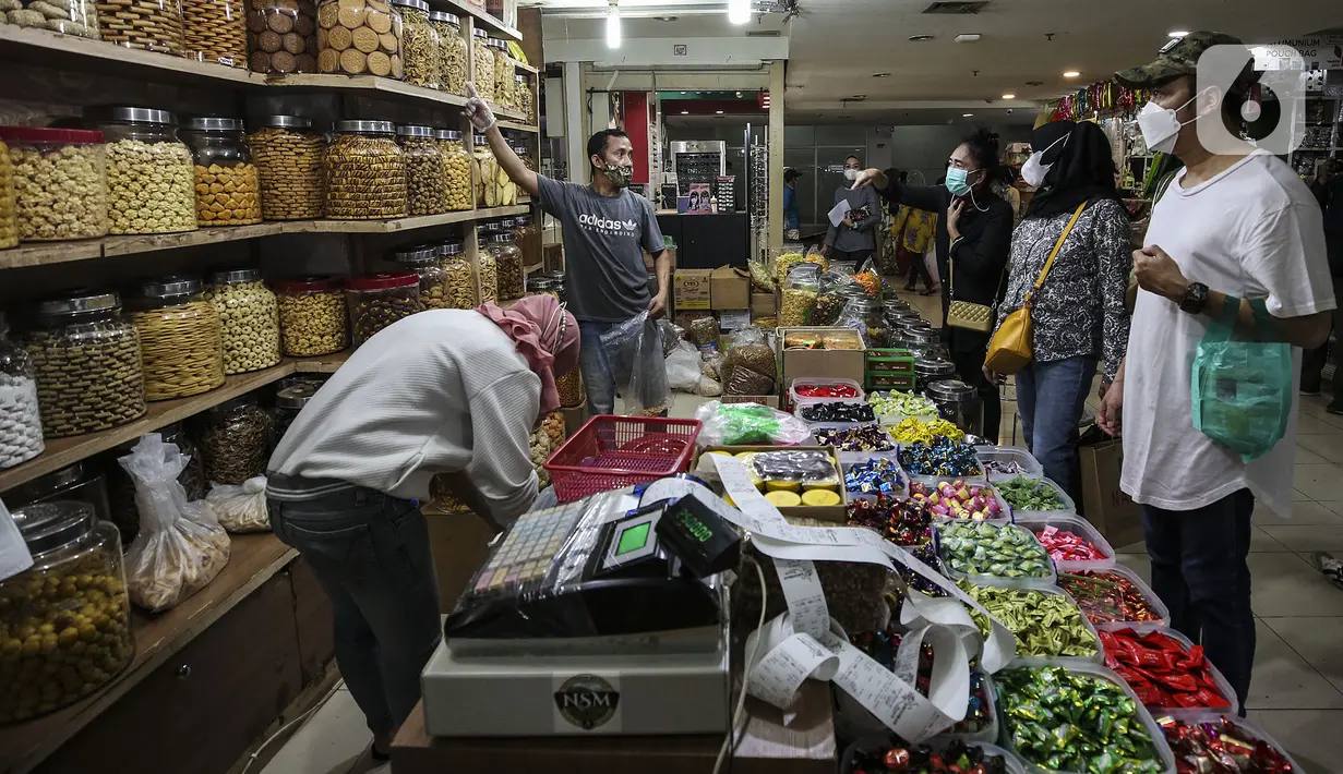 Pedagang kue kering melayani pembeli di Pasar Mayestik, Jakarta, Senin (3/5/2021). Omzet penjualan kue kering menjelang Lebaran tahun ini mengalami peningkatan hingga 70 persen dari tahun sebelumnya yang mengalami penurunan hingga 70 persen. (Liputan6.com/Johan Tallo)