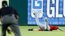 Pemain Cincinnati Reds, Scott Scheble (kanan) terjatuh saat gagal menangkap bola pukulan pemain Texas Rangers, Ryan Rua selama inning kedua pertandingan bisbol pramusim di Arlington, Texas (26/3). Texas menang 6-5. (AP Photo/Brandon Wade)