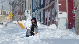Warga menggali salju untuk membuat jalan dari rumahnya di Kota St John's, Newfoundland, Kanada, Sabtu (18/1/2020). St John's menghadapi keadaan darurat ketika salju tebal memaksa pusat-pusat bisnis tutup dan kendaraan dilarang melintas di jalan raya. (Andrew Vaughan/The Canadian Press via AP)