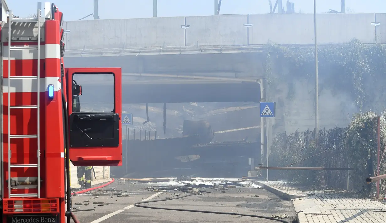 Kepulan asap terlihat dari lokasi ledakan truk tangki di jalan raya dekat kota Bologna,  Italia, Senin (6/8). Beberapa orang terluka diakibatkan terkena kaca yang berterbangan ketika jendela di gedung-gedung di dekatnya meledak. (Gianni SCHICCHI/AFP)