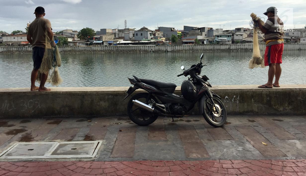 Warga yang hendak menjala ikan memarkirkan kendaraannya di trotoar Danau Sunter, Jakarta, Jumat (19/1). Meskipun telah dibenahi, masih banyak warga yang memarkirkan sepeda motornya di trotoar tersebut. (Liputan6.com/Immanuel Antonius)