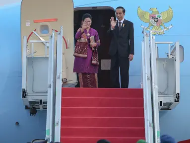 Presiden Jokowi dan Istri melambaikan tangan sebelum memasuki pesawat di Bandara Halim Perdana Kusuma, Jakarta,(24/10/2015). Tujuan utama Jokowi adalah meningkatkan hubungan bilateral, terutama investasi dan perdagangan. (Liputran6.com/Faizal Fanani)