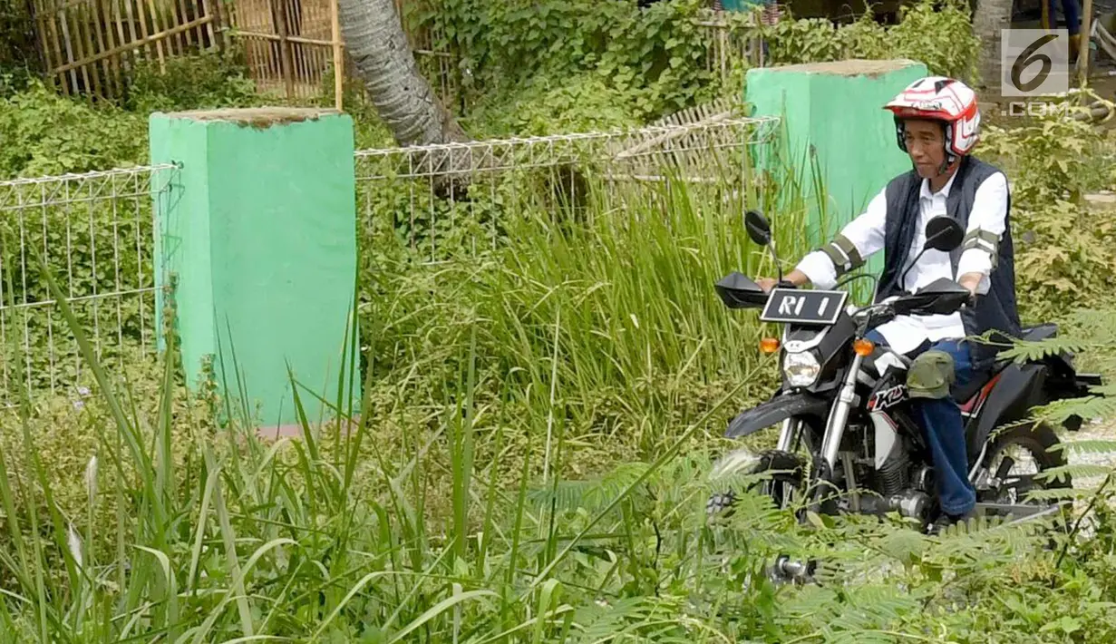 Presiden Joko Widodo mengendarai motor trail melintasi perkampungan di Muara Gembong, Bekasi (1/11). Jokowi menghadiri kegiatan Perhutanan Sosial untuk Pemerataan Ekonomi. (Liputan6.com/Biro Pers Kepresidenan/Agus Suparto)