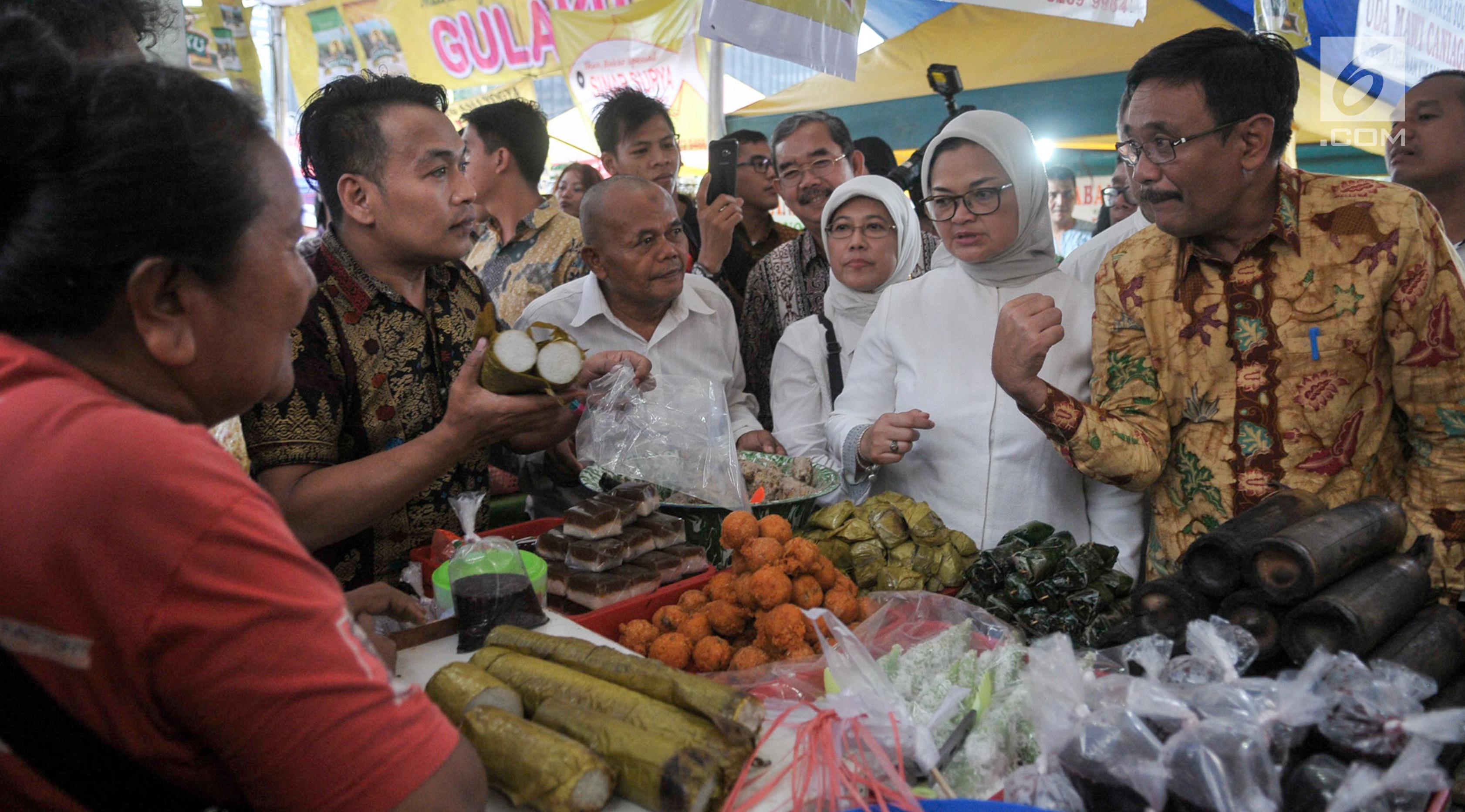 Plt Gubernur DKI Jakarta, Djarot Saiful Hidayat saat membeli lemang di pasar takjil Benhil, Jakarta, Jumat (2/6). Djarot meninjau pasar takjil Benhil serta membeli aneka makanan takjil tradisional. (Liputan6.com/Yoppy Renato)