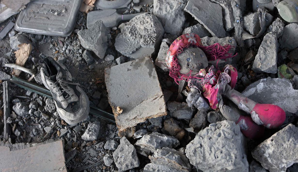 Bangunan tersebut menjadi tempat berlindung bagi puluhan keluarga pengungsi, dan para korban juga termasuk perempuan dan anak-anak. Tampak dalam foto, sebuah sepatu dan boneka terlihat di antara puing-puing bangunan yang rusak milik Kementerian Wakaf Agama, yang menjadi tempat penampungan bagi pengungsi di kawasan Zeitoun, Kota Gaza, pada Kamis 20 November 2025, sehari setelah bangunan tersebut menjadi sasaran serangan militer Israel. (Omar AL-QATTAA /AFP)