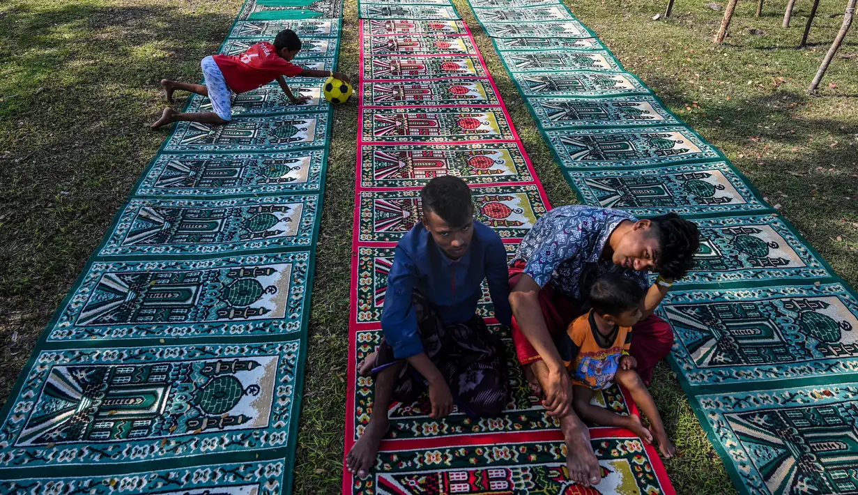 Pengungsi Rohingya mandi di tempat penampungan sementara di Ladong, provinsi Aceh, Jumat 24 Februari 2023. Sedikitnya 69 pengungsi Rohingya mendarat di pantai barat Indonesia pada 16 Februari lalu dengan sebuah perahu kayu, kata seorang pejabat badan pengungsi PBB. (CHAIDEER MAHYUDDIN/AFP)