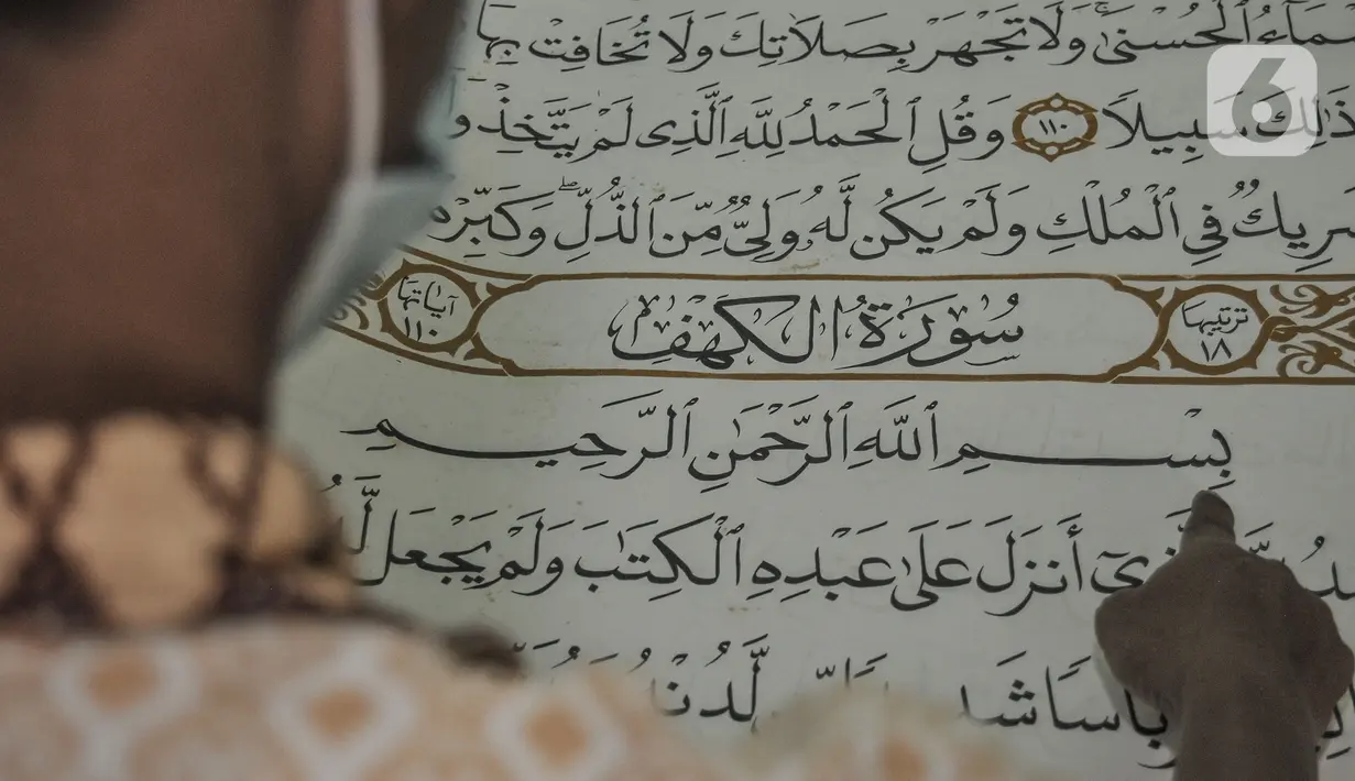 Petugas membaca sepenggal ayat dari Alquran raksasa koleksi Perpustakaan Jakarta Islamic Center (JIC), Kamis (22/4/2021). Alquran ini seluruhnya dibuat dan ditulis tangan oleh santri Universitas Sains Alquran Wonosobo, mulai dari ayat, hingga nomor halaman. (merdeka.com/Iqbal S Nugroho)