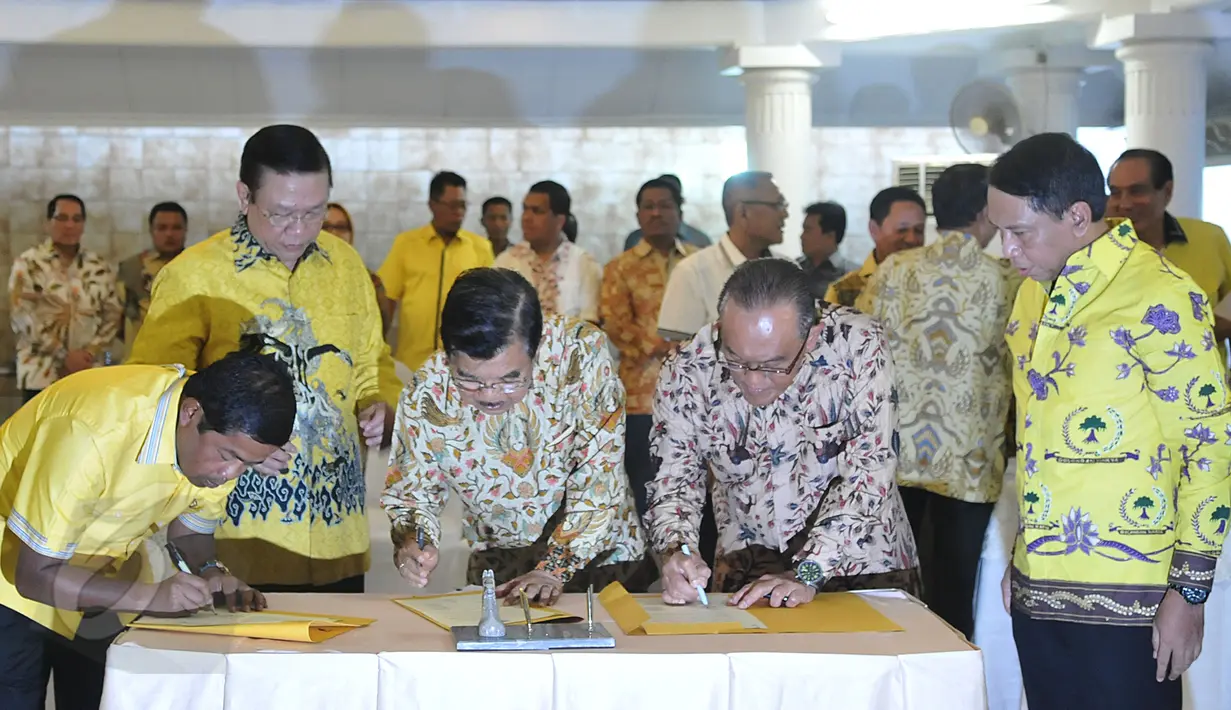 Wapres Jusuf Kalla (tengah) bersama Ketum Partai Golkar versi munas Bali Aburizal Bakrie dan Ketum Partai Golkar versi munas Ancol Agung Laksono (kedua kiri) saat penandatangan berkas kesepakatan islah di Jakarta, Sabtu (30/5). (Liputan6.com/Johan Tallo)