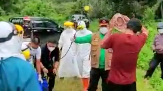 Sebelum memasuki ambulans, Udin disiram disinfektan.(Liputan6.com/Ahmad Akbar Fua)