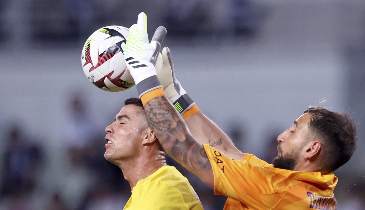 Pemain Al Nassr, Cristiano Ronaldo (kiri), berebut bola di udara dengan penjaga gawang PSG, Gianluigi Donnarumma dalam pertandingan uji coba yang berlangsung di Nagai Stadium, Osaka, Selasa (25/7/2023). (AFP/Paul Miller)
