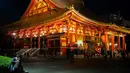 Seorang wanita melihat ponselnya di dekat kuil Asakusa di Tokyo (1/12). Pada abad kedua puluh, Asakusa adalah daerah hiburan utama di Tokyo. (AFP Photo/Martin Bureau)