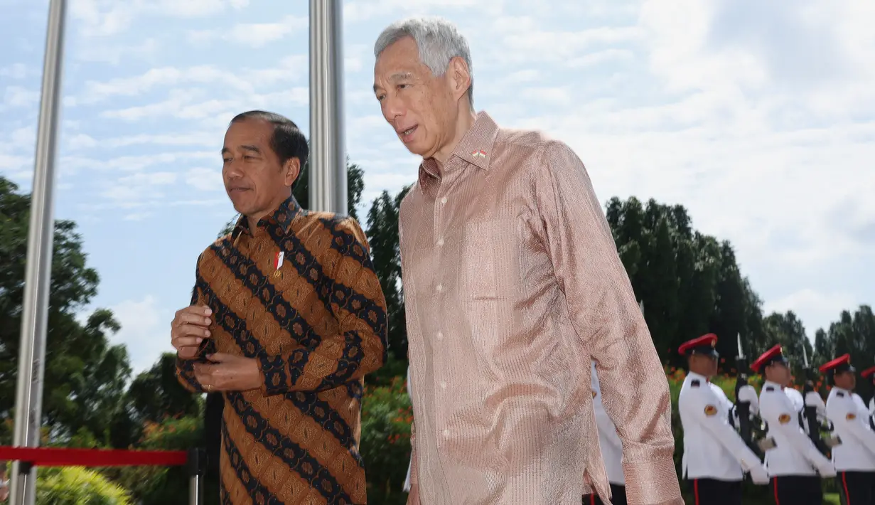 Begitu turun dari mobil, Jokowi disambut langsung oleh Lee dan berjalan bersamaan menuju ke dalam istana. (EDGAR SU/POOL/AFP)