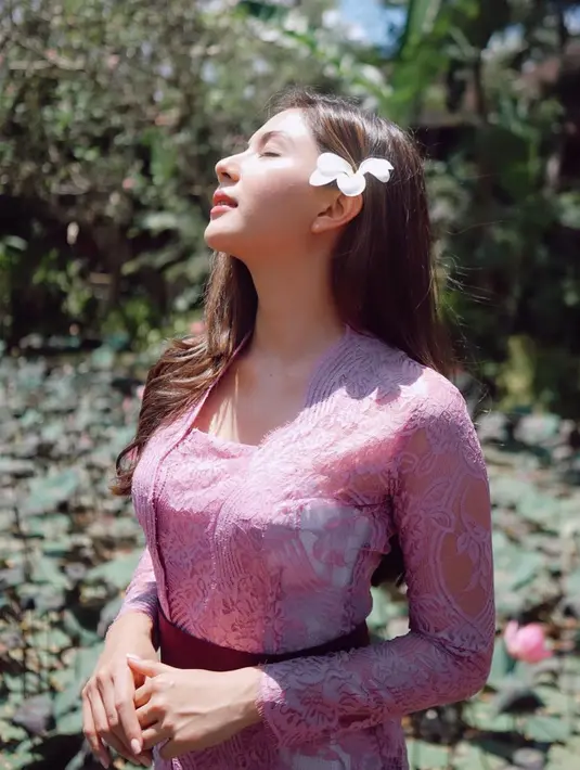 Cantiknya Jessica Mila dalam balutan kebaya Bali. Berpose di bawah sinar matahari yang menunjukkan kecantikan alami parasnya, Jessica Mila memilih mengenakan kebaya tradisional Bali berwarna ungu, diikat dengan selendang tipis berwarna ungu tua yang serasi. Foto: Instagram.