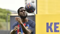 Gelandang baru Barcelona, Franck Kessie mengontrol bola selama upacara presentasi di tempat latihan Joan Gamper di Sant Joan Despi, dekat Barcelona (6/7/2022). Kessie menerima pinangan Barcelona yang berani membayar gaji 6-7 juta euro. (AFP/Pau Barrrena)