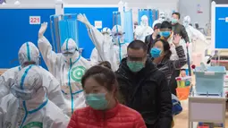 Petugas medis mendampingi para pasien yang telah sembuh saat berjalan keluar dari rumah sakit sementara Wuchang di Wuhan, Provinsi Hubei, 10 Maret 2020. Kelompok terakhir 49 pasien yang telah sembuh dari COVID-19 meninggalkan rumah sakit sementara Wuchang pada Selasa (10/3) sore. (Xinhua/Xiao Yijiu)