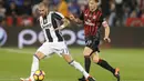 Gelandang Juventus, Stefano Sturaro, berusaha melewati bek AC Milan, Ignazio Abate, pada laga Piala Super Italia 2016. Juventus lebih menguasai jalannya laga dengan penguasaan bola 52 persen. (AFP/Karim Jaafar)