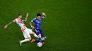 Pemain Timnas Jepang, Wataru Endo (kanan) berebut bola dengan pemain Timnas Kroasia, Brozovic pada laga 16 besar Piala Dunia 2022 di Al-Janoub Stadium, Al-Wakrah, Qatar, 5 Desember 2022. (AFP/Anne-Christine Poujoulat)