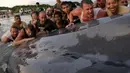 Sekitar 50 orang wisatawan berusaha membawa paus seberat 79 ribu pon kembali ke laut, Pantai Popoyo, Nicaragua, Jumat (14/11/2014) (AFP Photo/Inti Ocon)