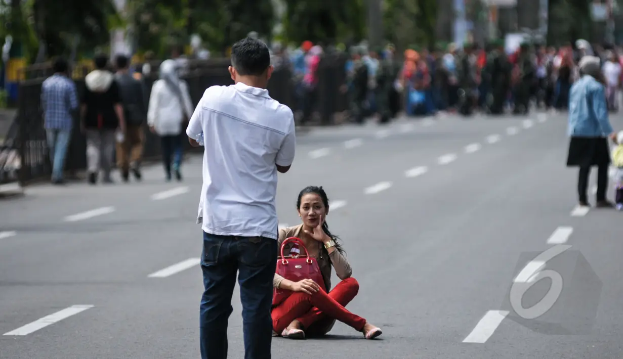 Warga berfoto di Jalan Asia Afrika, Bandung yang sedang disterilkan dari kendaraan bermotor, Jumat (24/2015). Pensterilan jalan diberlakukan saat berlangsungnya puncak perayaan ke-60 Konferensi Asia Afrika di Bandung. (Liputan6.com/Faizal Fanani)