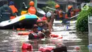 Petugas Pemadam Kebakaran mengevakuasi anak-anak korban banjir dengan menggunakan ban di kawasan Karet Pasar Baru Barat, Jakarta, Selasa (25/2/2020). Banjir yang terjadi sejak subuh akibat luapan Kanal Banjir Barat tersebut merendam ratusan rumah hingga setinggi dua meter. (merdeka.com/Arie Basuki)