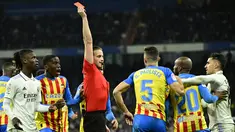 Wasit Javier Alberola Rojas memberikan kartu merah kepada pemain Valencia, Gabriel Paulista saat melawan Real Madrid pada laga Liga Spanyol di Stadion Santiago Bernabeu, (2/2/2023). Real Madrid meraih kemenangan penting pada pekan ke-17 Liga Spanyol 2022/2023. (AFP/Javier Soriano)