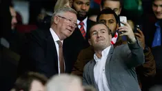 Mantan manajer Manchester United Sir Alex Ferguson berselfie dengan fans saat menyaksikan pertandingan antara Manchester United dengan Chelsea di Stadion Old Trafford, Inggris (28/12). MU bermain imbang dengan Chelsea dengan skor 0-0. (Reuters/Phil Noble)