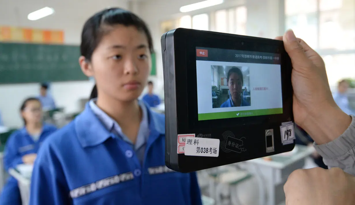  Salah satu peserta ujian melewati pemeriksaan menggunakan pendeteksi wajah selama simulasi di Handan, Provinsi Hebei, China, (6/6). Sebanyak 9,4 juta lulusan SMA China akan mengikuti ujian masuk perguruan tinggi atau Gaokao. (AFP/STR)