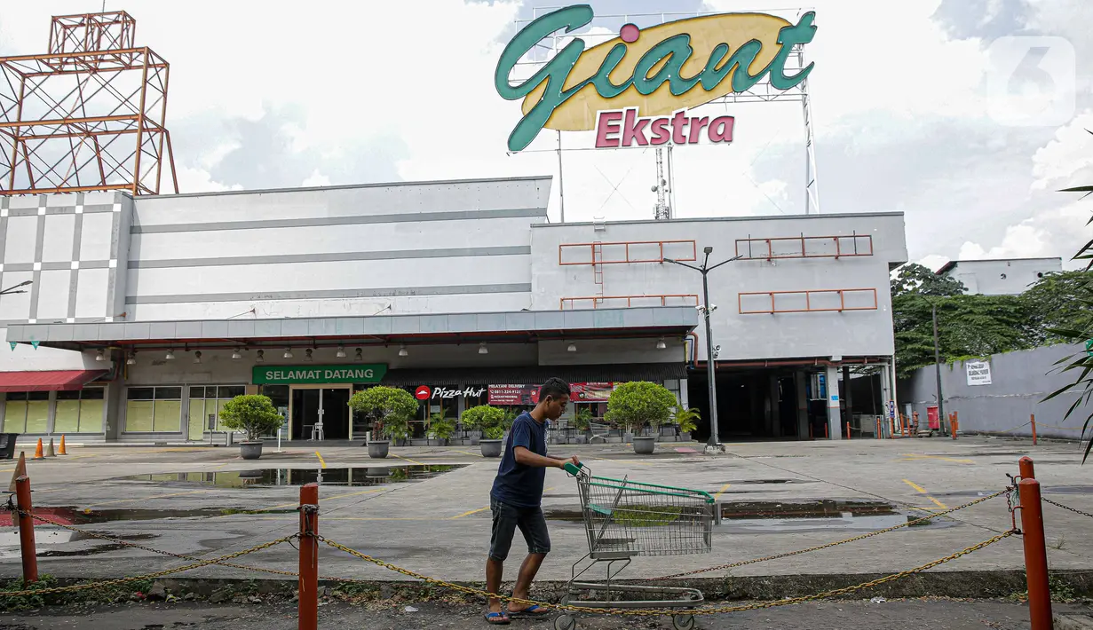 Pengunjung melintas di depan Supermarket Giant Ekstra di Kreo, Tangerang, Senin (2/8/2021). PT Hero Supermarket Tbk resmi menutup seluruh gerai Giant di Indonesia pada Minggu (1/8/2021), dan akan lebih fokus pada pengembangan gerai merek lainnya. (Liputam6.com/Faizal Fanani)