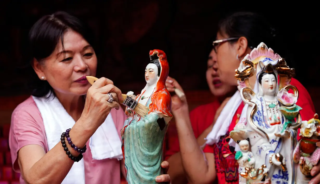 Para wanita membersihkan patung dewa Tionghoa dalam persiapan perayaan Tahun Baru Imlek di Vihara Dhanagun, Bogor, Jawa Barat, Indonesia, 16 Januari 2023. Warga keturunan Tionghoa di Indonesia bersiap untuk merayakan Tahun Baru Imlek pada 22 Januari 2023. (AP Photo/Tatan Syuflana)