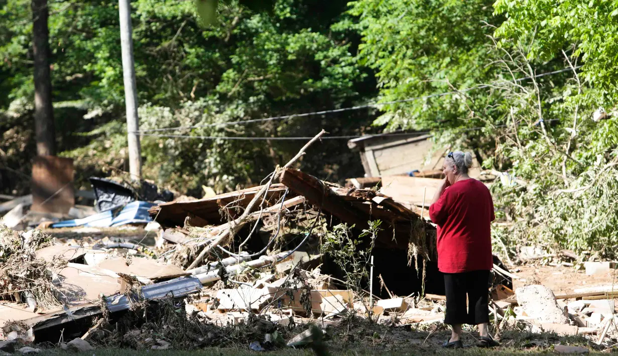 Emma Allen (58) mengamati puing rumahnya yang dilanda banjir dahsyat di Falling Rock, Virginia Barat, Minggu (26/6). Status darurat sudah dinyatakan di 44 dari 55 wilayah setingkat kota di negara bagian tersebut. (REUTERS/Marcus Constantino)
