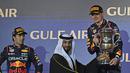 Pembalap Red Bull Racing, Max Verstappen (kanan) menerima trofi saat memenangkan Formula 1 GP Bahrain 2024 yang berlangsung di Sirkuit Sakhir, Bahrain, Sabtu (03/03/2024) malam WIB. (AFP/Andrej Isakovic)