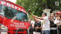 Sekretaris Tim Kampanye Nasional Hasto Kristiyanto mengguyur minibus tim pemenangan Joko Widodo-Ma'ruf Amin saat peluncuran di Jakarta, Senin (27/8). Sebanyak lima minibus pemenangan diluncurkan untuk wilayah Jawa Barat. (Liputan6.com/Herman Zakharia)