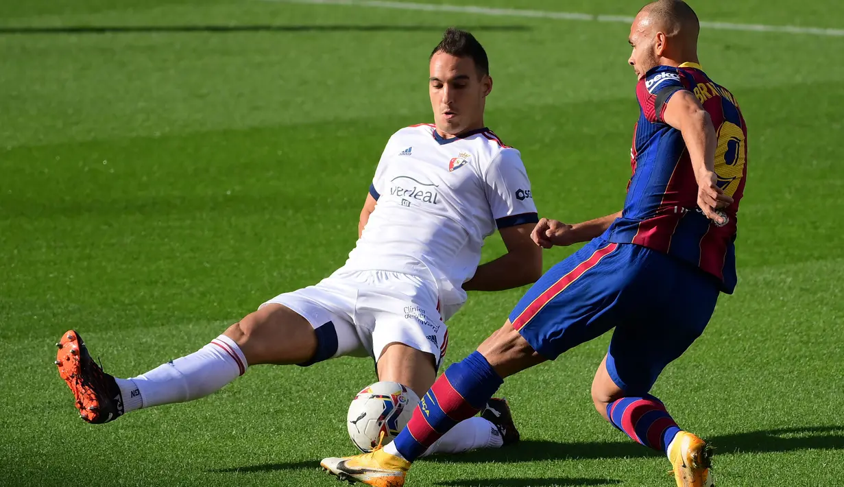 Bek Osasuna, Unai Garcia (kiri) berebut bola dengan pemain depan Barcelona, Martin Braithwaite pada pekan ke-11 Liga Spanyol 2020-2021di stadion Camp Nou, Minggu (29/11/2020). Barcelona berhasil pesta gol 4-0 saat menjamu Osasuna. (LLUIS GENE / AFP)