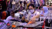 Calon pembeli memilih pakaian impor bekas di Pasar Senen, Jakarta, Kamis (9/3/2023). Larangan impor baju bekas tercantum dalam Peraturan Menteri Perdagangan (Permendag) No.18/2021 tentang Barang Dilarang Ekspor dan Barang Dilarang Impor. (Liputan6.com/Faizal Fanani)
