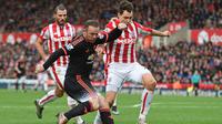 Striker Manchester United, Wayne Rooney (seragam hitam), gagal menyelamatkan timnya dari kekalahan 0-2 saat melawan Stoke City di Britannia Stadium, Sabtu (26/12/2015) malam WIB. (AFP/Paul Ellis)