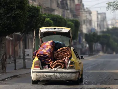 Sebuah mobil berisi kasur melaju di jalanan yang sepi di kota Gaza pada 11 Oktober 2023. (Mohammed ABED/AFP)