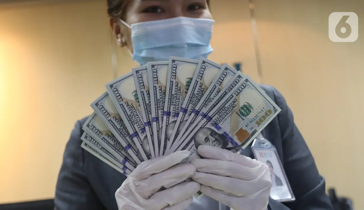 Karyawan bank menunjukkan mata uang dolar Amerika Serikat (AS) di Jakarta, Senin (2/11/2020). Nilai tukar rupiah pada perdagangan Senin (2/11) sore ditutup melemah 0,1 persen ke level Rp14.640 per dolar AS, dari perdagangan sebelumnya yaitu Rp14.690 per dolar AS. (Liputan6.com/Angga Yuniar)