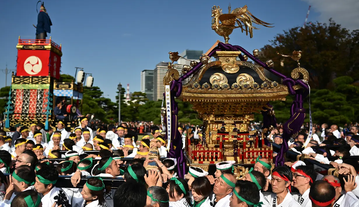 Peserta berkumpul selama perayaan nasional untuk menandai penobatan Kaisar Jepang Naruhito di depan Istana Kekaisaran di Tokyo (9/11/2019). Kaisar Naruhito menjalankan ritual penobatannya setelah dilantik pada 1 Mei 2019. (AFP Photo/Charly Triballeau)