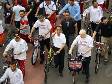 Presiden Joko Widodo (menunjuk) bersepeda bersama Walikota London, Boris Johnson di Jakarta, Minggu (30/11/2014). (Liputan6.com/Faizal Fanani)