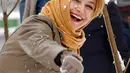 Seorang wanita melempar salju di Teheran, Selasa (24/1). Hampir setengah abad salju tak turun di Iran dan sejak 2011 hingga kini salju senantiasa turun di musim dingin. (AFP PHOTO / ATTA KENARE)   