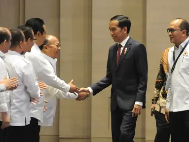 Presiden Jokowi dan Ketua Umum Kadin, Rosan P. Roeslani pada acara penutupan Rapimnas Kadin di Solo, Jawa Tengah, Rabu (28/11). Dalam pidatonya Jokowi berencana membatalkan rencana relaksasi Daftar Negatif Investasi (DNI). (Liputan6.com/Angga Yuniar)
